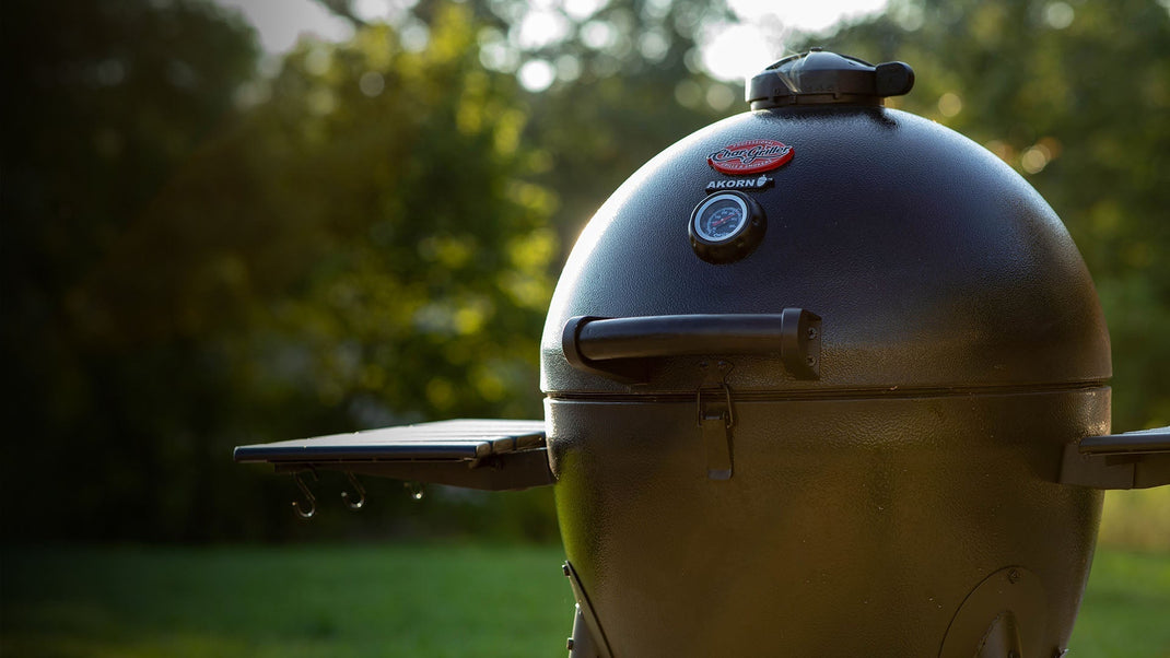 A closed AKORN grill glows in the soft light of a late afternoon
