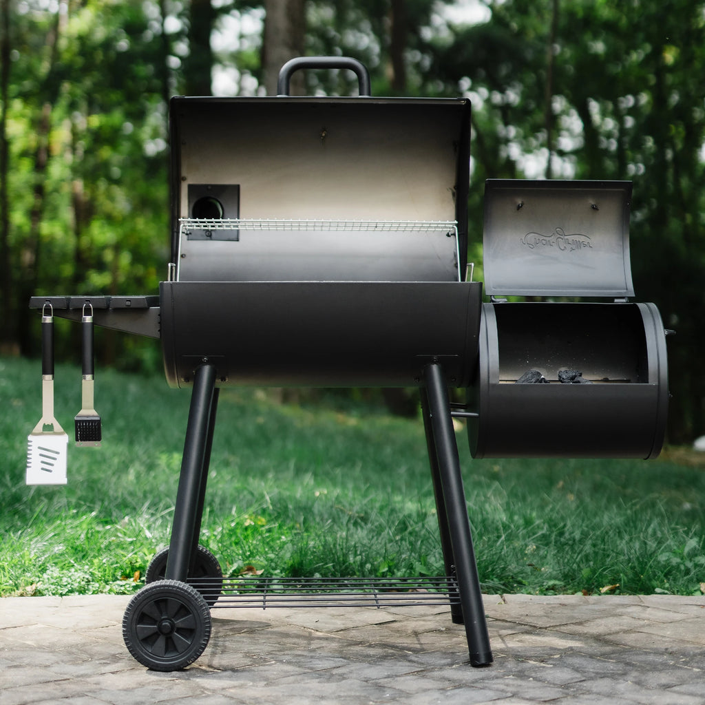 A Smokin' pro with mounted side fire box. Both grill and fire box are open. Lump charcoal can be seen piled in the side fire box.