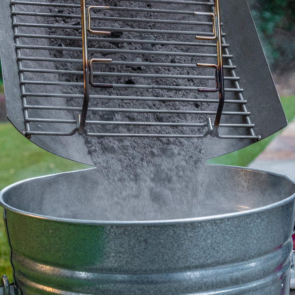 Dumping ashes from the EasyDump ash pan into a metal bucket