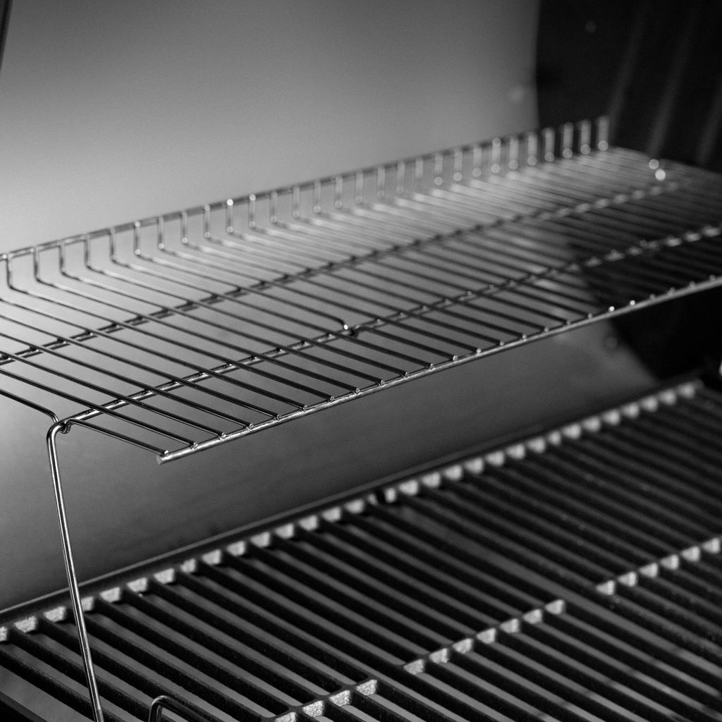 A chrome-plated warming rack sits above the cooking grate