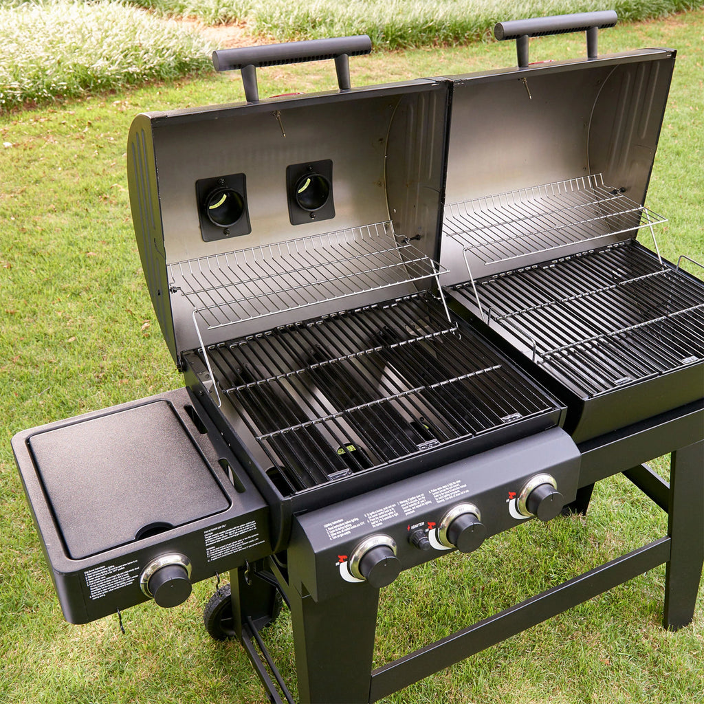 Looking into the open grill from above, with both lids open. The 3 gas burners can be seen inside the gas (left) side.