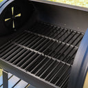 Inside view of the tabletop grill with the lid open showing the cast iron cooking grate above a smaller metal fire grate. The left side damper is slightly open.